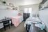 Charming twin-bedroom with cozy decor, ample natural light, and organized shelf space, ideal for a relaxing and productive atmosphere.