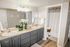 Elegant bathroom with dual sinks, modern cabinetry, and a large mirror, showcasing a bright and airy ambiance.