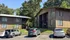 Charming apartment buildings nestled in a lush green setting with convenient parking area and inviting architecture.