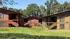 Charming apartment complex surrounded by lush greenery, featuring wood-paneled exteriors and spacious outdoor areas for relaxation.