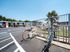 Vibrant apartment complex with secure bicycle parking and lush palm trees, showcasing a sunny and welcoming community environment.