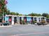 Chic duplex apartment complex with vibrant blue and red accents, surrounded by lush greenery and dedicated parking spaces.