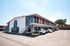 Charming two-story apartment complex with modern facade, spacious parking, and inviting balconies.