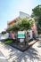 Bright leasing office exterior at University View Denton, featuring vibrant pink accents and lush greenery, welcoming potential residents.