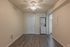 Bright and efficient laundry nook with a modern stacked washer-dryer in stylish apartment, featuring elegant wood flooring and ample lighting.