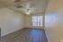 Inviting living room with hardwood floors, large window for natural light, and ceiling fan in a cozy apartment.