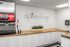 Modern kitchen area in Alpine Village featuring a sleek soda dispenser, white cabinetry, and elegant countertop space.