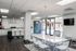 Modern apartment lobby featuring a sleek communal area with a glossy white table, stylish chairs, and a welcoming bar counter at Alpine Village.