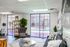Bright and stylish apartment lounge with modern furniture, large windows, and elegant decor overlooking a charming courtyard.