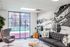 Bright and modern living room with a large window, stylish gray sofa, cozy accent chair, and a stunning mountain mural, offering a perfect blend of comfort and elegance.