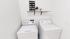 Chic laundry room with modern washer and dryer, featuring stylish decor on a wooden shelf and a playful laundry schedule sign.
