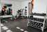 Modern fitness center equipped with free weights, weight lifting bench, and vibrant exercise balls in a bright, spacious setting.