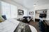 Bright and cozy twin bedroom featuring large windows, modern shelving, and ample study space for an inviting and functional living environment.