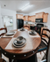 Inviting kitchen with wooden cabinetry, modern appliances, and elegant dining setup, highlighting a warm and stylish living space.