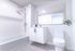 Bright, modern bathroom with sleek fixtures, large mirror, and minimalist decor.