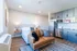 Bright studio apartment featuring a cozy bed, modern kitchenette, and stylish sofa.