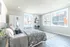 Bright and airy urban bedroom with modern decor and large windows allowing natural light.