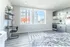 Bright studio apartment with modern kitchen, cozy bed, and a stylish workspace.