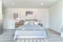 Bright and inviting bedroom featuring a cozy bed with patterned linens and stylish decor.