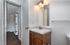 Modern bathroom featuring sleek fixtures, warm wooden cabinetry, and elegant lighting.