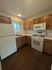 Charming kitchen with natural wood cabinets, modern appliances, and a cozy atmosphere.