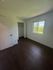 Bright and airy bedroom featuring sleek hardwood floors, a spacious closet, and a window with scenic outdoor views.