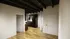 Inviting apartment interior showcasing a sleek wooden floor, modern kitchen with dark wood cabinetry, and stylish ceiling beams.
