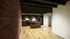 Modern kitchen with sleek wooden cabinets, central island, and striking exposed brick wall, perfect for contemporary living.