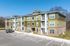 Charming three-story apartment building with modern design, spacious balconies, and ample parking in a serene neighborhood.
