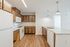 Modern kitchen with sleek wooden cabinetry, spacious countertops, and high-end appliances, illuminated by elegant pendant lighting.