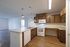 Modern open-concept kitchen with sleek countertops, warm wooden cabinets, and ample natural light, ideal for culinary enthusiasts.