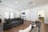 Bright and spacious living room with modern furniture, wooden flooring, and natural light streaming through large windows.