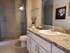 Luxurious bathroom featuring elegant marble countertops, modern fixtures, and a spacious glass-enclosed shower, creating a serene spa-like atmosphere.