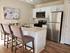Bright and modern kitchen with sleek stainless steel appliances, elegant marble countertop, and cozy bar seating for three.