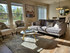 Bright and inviting living room featuring elegant decor, plush seating, and abundant natural light from large windows, perfect for relaxation and gatherings.