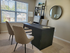 Elegant home office with natural light, featuring a sleek desk, comfortable beige chairs, and modern decor.