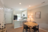Bright and inviting dining area with a modern open kitchen, featuring sleek appliances and stylish decor.