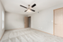 Bright and inviting empty room with plush carpet and modern ceiling fan, perfect for personalizing your space.