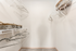 Spacious walk-in closet with organized shelving, elegant hangers, and stylish woven baskets. Perfect for storage and accessibility in any modern apartment.