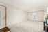 Bright and welcoming living room with plush carpet, large window, and elegant decor, perfect for a cozy home atmosphere.