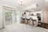 Chic kitchen with modern appliances, stylish bar seating, and ample natural light from sliding glass doors.