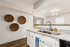 Modern kitchen with stylish granite countertops, dual sinks, and elegant lighting, featuring decorative wall accents and a cozy ambiance.