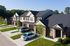 Charming row of modern townhouses with attractive brickwork, lush green lawns, and private driveways, set in a tranquil neighborhood.