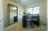 Bright and cozy dining area with a large mirror enhancing space, featuring elegant black furniture and a sunlit window view.