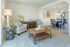 Bright and inviting living room with cozy armchairs, a chic coffee table, and a view into the modern dining area and kitchen.
