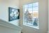 Bright stairwell with large window view and elegant floral artwork, offering a touch of nature indoors.