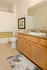 Bright and inviting bathroom with elegant granite countertop, stylish wooden cabinetry, and modern fixtures, enhanced by a chic shower curtain and decorative rug.