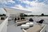 Chic rooftop terrace with modern seating, lush greenery, and expansive views under a clear sky.