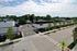 Charming suburban view featuring tree-lined streets, modern parking spaces, and well-maintained sidewalks under a bright, blue sky.