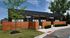 Modern townhouse with sleek black exterior, wooden privacy fence, and lush landscaping, nestled in a serene suburban setting.